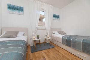 zwei Betten in einem Zimmer mit Fenster in der Unterkunft Seafront Maris by EL-PI TOURS in Dobrinj