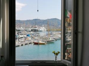 ventana con vistas a un puerto deportivo con barcos en Casa Vacanze Iris, en Imperia