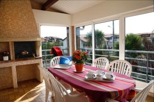 - une table avec des chaises et un ordinateur portable sur un balcon dans l'établissement Résidence d'Aquitaine, à Vieux-Boucau-les-Bains