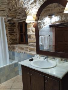 a bathroom with a sink and a mirror and a tub at Vouno Village in Vounós +109 photos