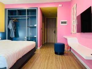 a bedroom with a bed and a pink wall at Hải Tiến Be Home in Hoằng Hóa