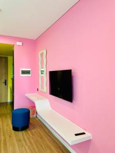 a room with a pink wall with a tv on it at Hải Tiến Be Home in Hoằng Hóa