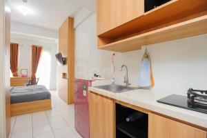 a kitchen with a sink and a room with a bed at RedLiving Apartment Patra Land Urbano - Alfa Rooms Tower East in Bulanbulan