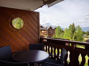 a table and chairs on a balcony with a view at Apartment Jade 22 by Interhome in Villars-sur-Ollon