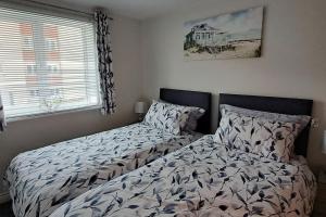 a bedroom with two beds and a window at 2 bedroom apartment in Stratford upon Avon with free onsite parking in Stratford-upon-Avon