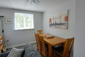a living room with a table and a couch at 2 bedroom apartment in Stratford upon Avon with free onsite parking in Stratford-upon-Avon