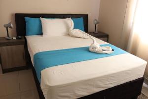 a bedroom with a bed with blue and white at Amariah Guesthouse - Kazungula in Kasane
