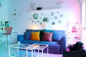 Una sala de estar con un sofá azul con almohadas de colores. en The Greenhouse Madrid, en Madrid