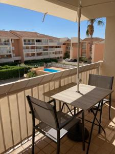 a table and chairs on a balcony with an umbrella at Le Ciel Bleu in La Seyne-sur-Mer