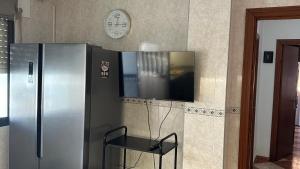 a kitchen with a refrigerator and a tv on the wall at Villa Gení La Victoria by Ruralidays in La Victoria