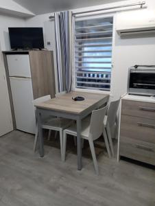 レージュ・キャップ・フェレにあるCamping Siblu Mobilhome 2 chambresの窓付きのキッチン(テーブル、椅子付)
