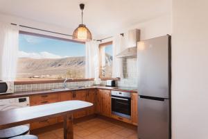 a kitchen with a stainless steel refrigerator and a window at Villa Upupa in La Oliva