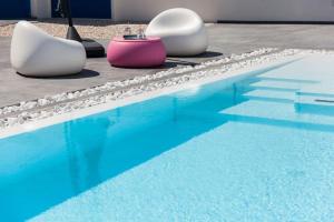 two chairs sitting next to a swimming pool at Leonida's Home - Shared Pool, Jacuzzi and beach 150mt in Su Forti