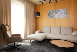 a living room with a white couch and a chair at Air Hotel in Karmėlava