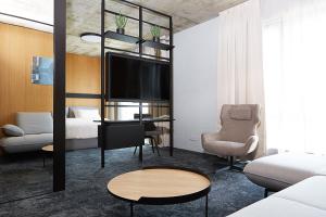 a living room with a bed and a tv at Air Hotel in Karmėlava