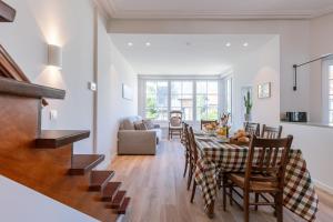 a dining room and living room with a table and chairs at Maison Welkom in De Panne