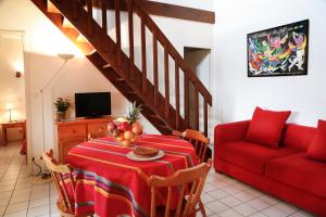 a living room with a table and a red couch at Résidence d'Aquitaine in Vieux-Boucau-les-Bains
