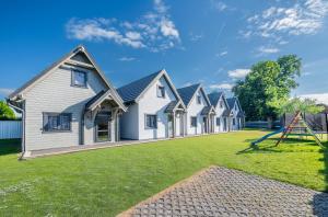 a row of houses on a lawn at Domki Letniskowe Maks in Bobolin