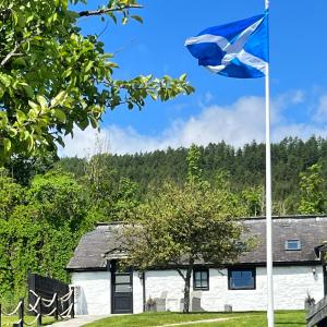 a flag flying in front of a house at The Old Manse of Blair, Boutique Hotel & Restaurant in Blair Atholl