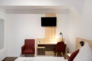 a hotel room with a desk and two chairs at Heikes Ferienwohnung in Schauenburg