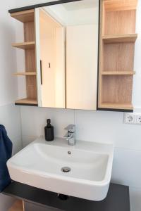 Un baño con un lavabo blanco y un espejo. en Potsdams Traumwohnung, en Potsdam