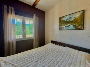 Un dormitorio con una cama y un cuadro en la pared. en Two bedroom Challet Snow white, en Kolašin