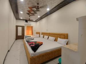 a bedroom with a large bed in a room at Hotel Shree Balaji in Ujjain