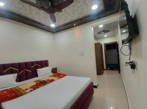 a bedroom with a bed and a ceiling fan at Hotel Shree Balaji in Ujjain