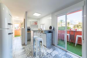 cocina con electrodomésticos blancos y ventana grande en Las Buganvillas, en Roquetas de Mar