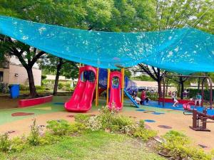 ein Spielplatz mit Rutsche in einem Park in der Unterkunft WNSuites in Manila