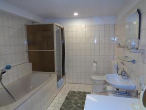 a bathroom with a tub and a toilet and a sink at Ferienwohnung Carmen in Spay +16 photos