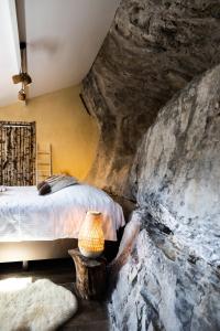 a bedroom with a bed and a rock wall at La grotte Dinant in Dinant