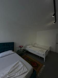 a room with two beds and a room with flowers at Sunny Rentals in Vlorë