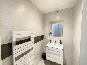 a white bathroom with a sink and a mirror at L oeillet Blanc - Maison familiale in Quiberon