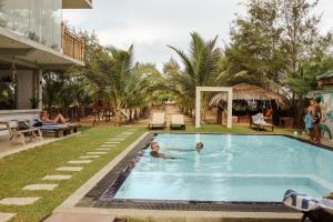 two children swimming in a pool at a resort at Stay Golden in Arugam Bay