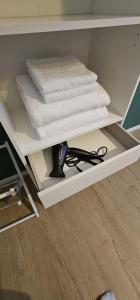 a white shelf with towels on top of it at B&B Casa Davide in Bergamo