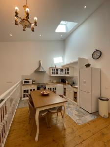 a kitchen with a table and a white refrigerator at Appartement standing proche plage in Fitou