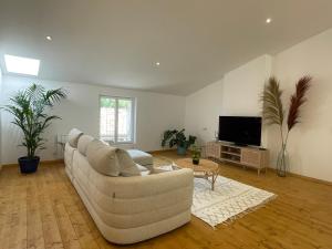 a living room with a white couch and a tv at Appartement standing proche plage in Fitou