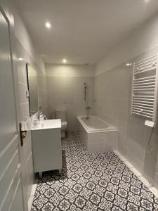 a bathroom with a sink and a tub and a toilet at Appartement standing proche plage in Fitou +3 photos