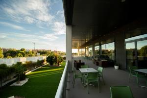 een balkon met tafels en stoelen in een gebouw bij AZZ Valencia Congress Hotel & Spa in Paterna