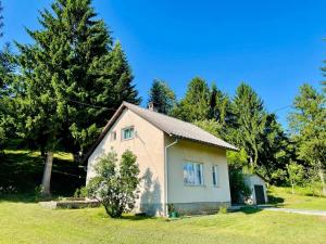 OštarijeHoliday home Metulum的树木繁茂的田野上的白色小房子