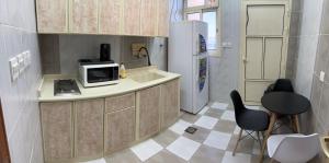 a kitchen with a counter with a microwave and a refrigerator at Rahwan Palace Serviced Apartments in Baljurashi