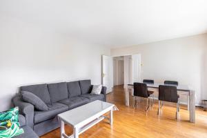 ein Wohnzimmer mit Sofa und Tisch in der Unterkunft GuestReady - Havre de Paix à Courbevoie in La Défense