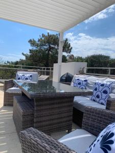 a patio with wicker chairs and a bar on a deck at Villa L'Amiraute in Agde