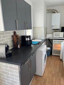 a kitchen with a washer and dryer on a counter at Normandy trip 5 min à pied de la plage in Courseulles-sur-Mer