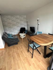 a living room with a table and a couch at Normandy trip 5 min à pied de la plage in Courseulles-sur-Mer +8 photos