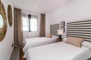 2 camas en una habitación de hotel con paredes blancas en Estepona Holiday Hills en Estepona