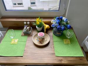 een tafel met groene servetten en een taart en bloemen erop bij SWEETHOME am WOOGBACH Speyer in Speyer