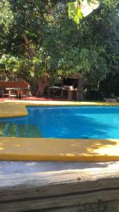 a blue swimming pool with a bench in the background at Cabaña Familiar en Vicuña in Vicuña