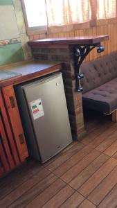 a small refrigerator next to a table and a bench at Cabaña Familiar en Vicuña in Vicuña